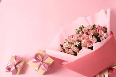 Pembe arka planda kadınlar için hediye kutusu ve çiçek günü.