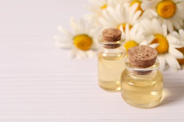 Şişede gerekli yağ ve masada çiçekler.