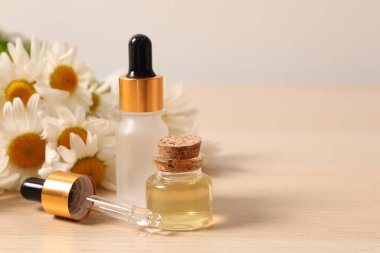 Şişe esans ve beyaz arka plan üzerinde papatya çiçeği