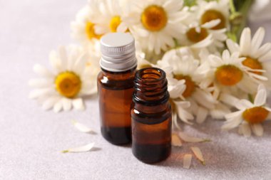 Beyaz arka planda temel yağ ve papatya çiçeği.