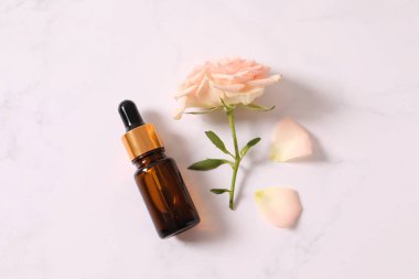 Beyaz masada gerekli yağlı gül şişesi.