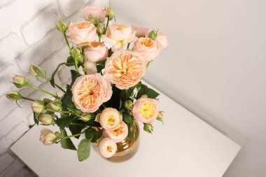 Vazodaki güzel çiçekler masada.