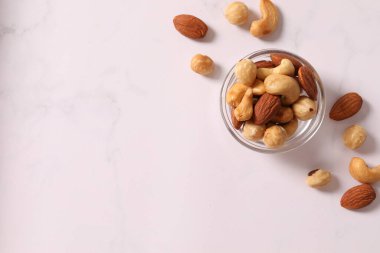 Lezzetli badem ve fındıklı kase beyaz ahşap masa, üst manzara
