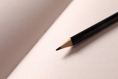 Masanın üzerinde kalem olan beyaz kağıt çarşafın üzerinde bir kalem..