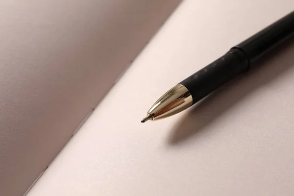 pen with blank paper for writing on a white background.