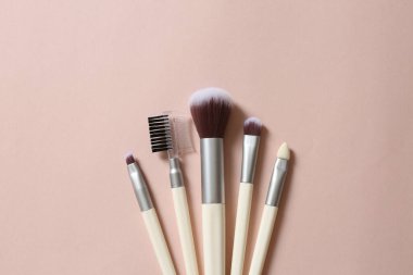 Pembe arka planda makyaj fırçaları
