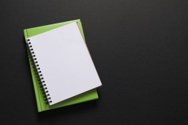 Siyah arkaplanda defter, kalem ve kalem.