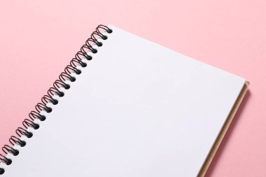 Pembe arkaplanda pembe kurdeleli boş bir defter, düz yatış, üst görünüm, tasarımın için maket.