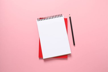 Renk arkaplanı üzerine not defteri ve kalem