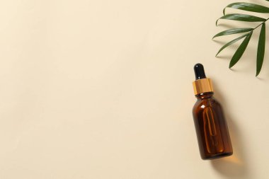 Bir bardak taze serum ve bej arka planda bir şişe. en üstteki görünüm