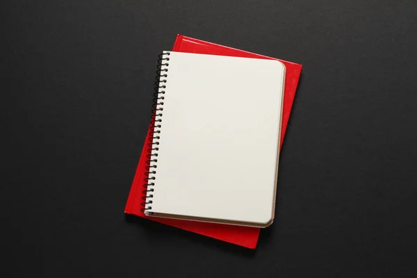 黒い背景に赤いペンが付いている空白のノートパッド — ストック写真