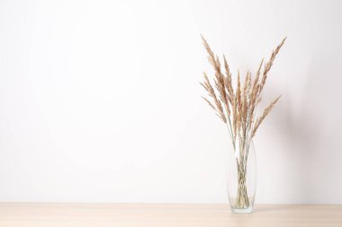 Masadaki vazoda kurumuş çiçekler.