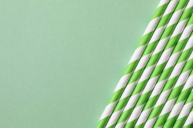 Beyaz arka planda yeşil plastik tek kullanımlık pipetlerin yakın plan çekimi.