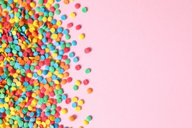 Pembe arka planda renkli çikolata şekeri