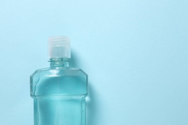 Mavi arka planda bir şişe su.