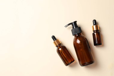 Doğal serum şişeleri ve bej arka planda boş etiket