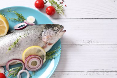 Tahta masada limonlu taze çiğ balık ve otlar.