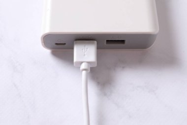 Beyaz arkaplanda cep telefonu için beyaz şarj cihazı.