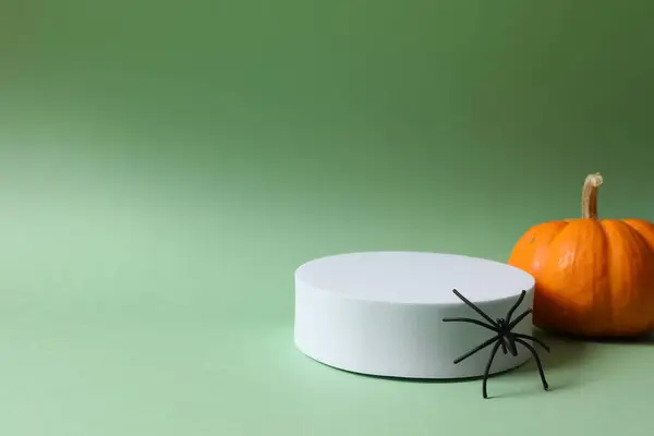 Stock image halloween pumpkin on a green background with white and black hat