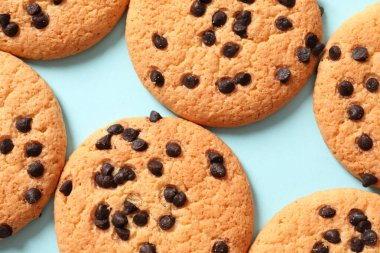 Çikolatalı kurabiyeler ve mavi arka planda kuru üzümler.