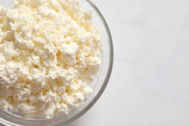 Açık arkaplanda bir kase süzme peynir