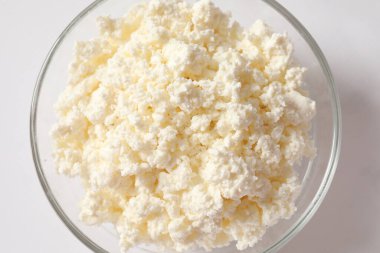 beyaz arka planda bir tabakta süzme peynir