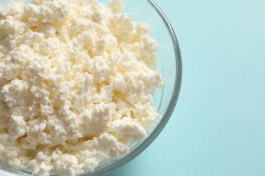 Mavi arka planda cam bir kavanozda süzme peynir..