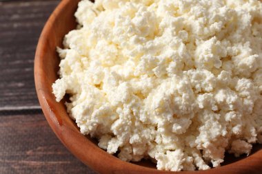 Ahşap arka planda süzme peynirli kase