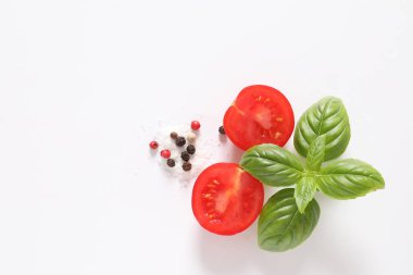 Beyaz arka planda taze domates, fesleğen ve baharatlar. Fotokopi alanı, sağlıklı beslenme konsepti. Taze domates, fesleğen, zeytinyağı