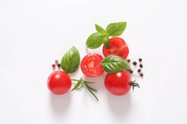 Beyaz arka planda domates ve taze fesleğen yaprakları
