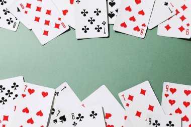 yeşil bir arka plan üzerinde oyun kartları.