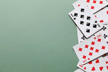 yeşil bir arka plan üzerinde oyun kartları.