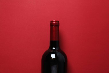 Renkli arka planda bir şişe kırmızı şarap.