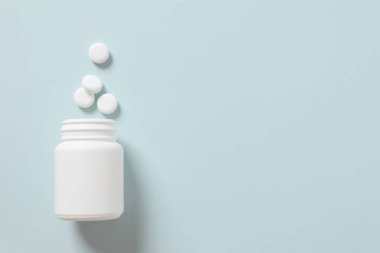 Renkli arka planda haplarla dolu bir şişe. 