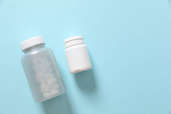 Bottles with pills on a colored background 