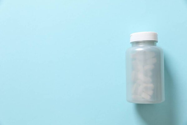 Bottle with pills on a colored background 