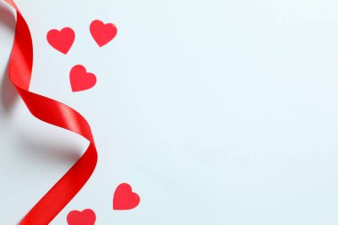 Renkli arkaplanda kurdeleli kırmızı kalpler, üst görünüm