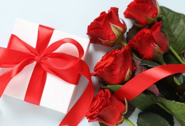 Güzel bir hediye ve kırmızı bir buket gül.