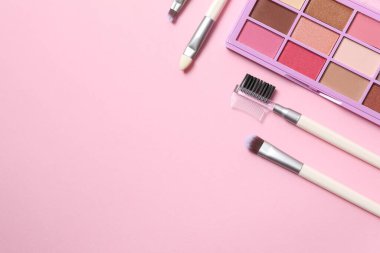 Renkli arkaplanda fırçalar olan makyaj paleti