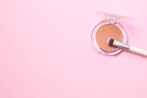 Make-up powder with a brush on a colored background