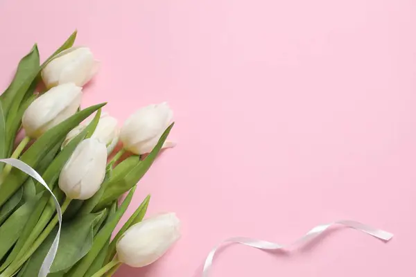 Beautiful white tulips on colored background