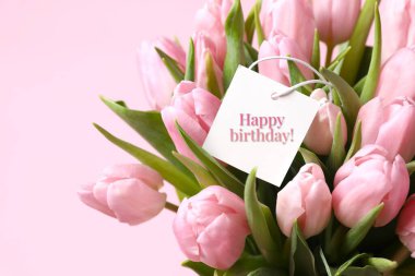 Üzerinde kart olan güzel bir buket lale çiçeği, yakın çekim. Mutlu yıllar için kartpostal 