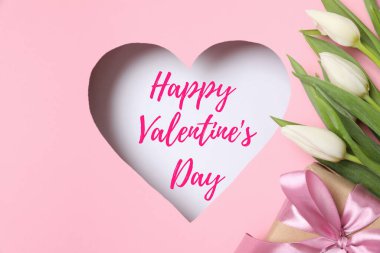 Pembe arka planda taze bahar laleleri olan bir kalp. Düz yatış, üst görünüm. 