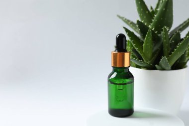 Cilt bakımı ile yüz kremi ve aloe. Mavi arka planda pipeti olan cam bir şişe. Kuru cilt bakımı ürünü. Vücudun derisini nemlendirmek için gerekli yağ..