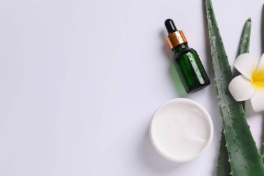 Beyaz arka planda taze aloe vera yapraklı kozmetik serumu ve krem. Organik kozmetik ürünleri. Üst görünüm düzlüğü, kopyalama alanı. Kozmetik, SPA markalaşması.
