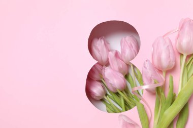 Pembe arka planda taze bahar laleleri olan 8 numara. Asgari Kadınlar Günü, 8 Mart ya da doğum günü konsepti. Düz yatış, üst görünüm.