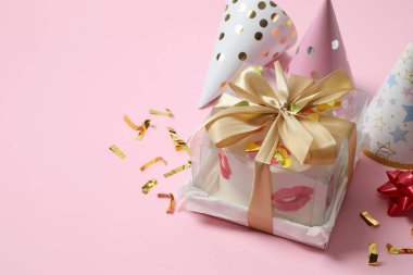 Renkli arka planda mumları ve şapkaları olan doğum günü pastası