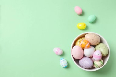 Renkli arka planda bir kasede paskalya yumurtaları.