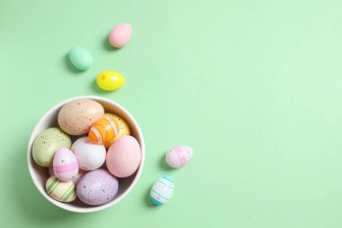 Renkli arka planda bir kasede paskalya yumurtaları.