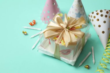 Renkli arka planda mumları ve şapkaları olan doğum günü pastası